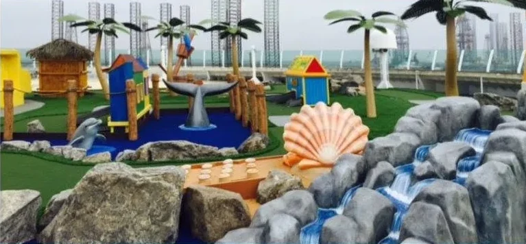 The finished playscape installed on deck, with the painted palms among themed rock and water features